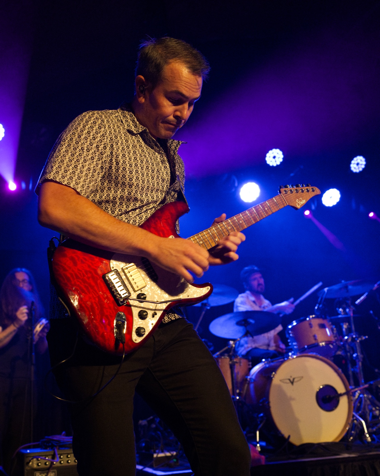 Bassist smiling and pointing at the camera during a set