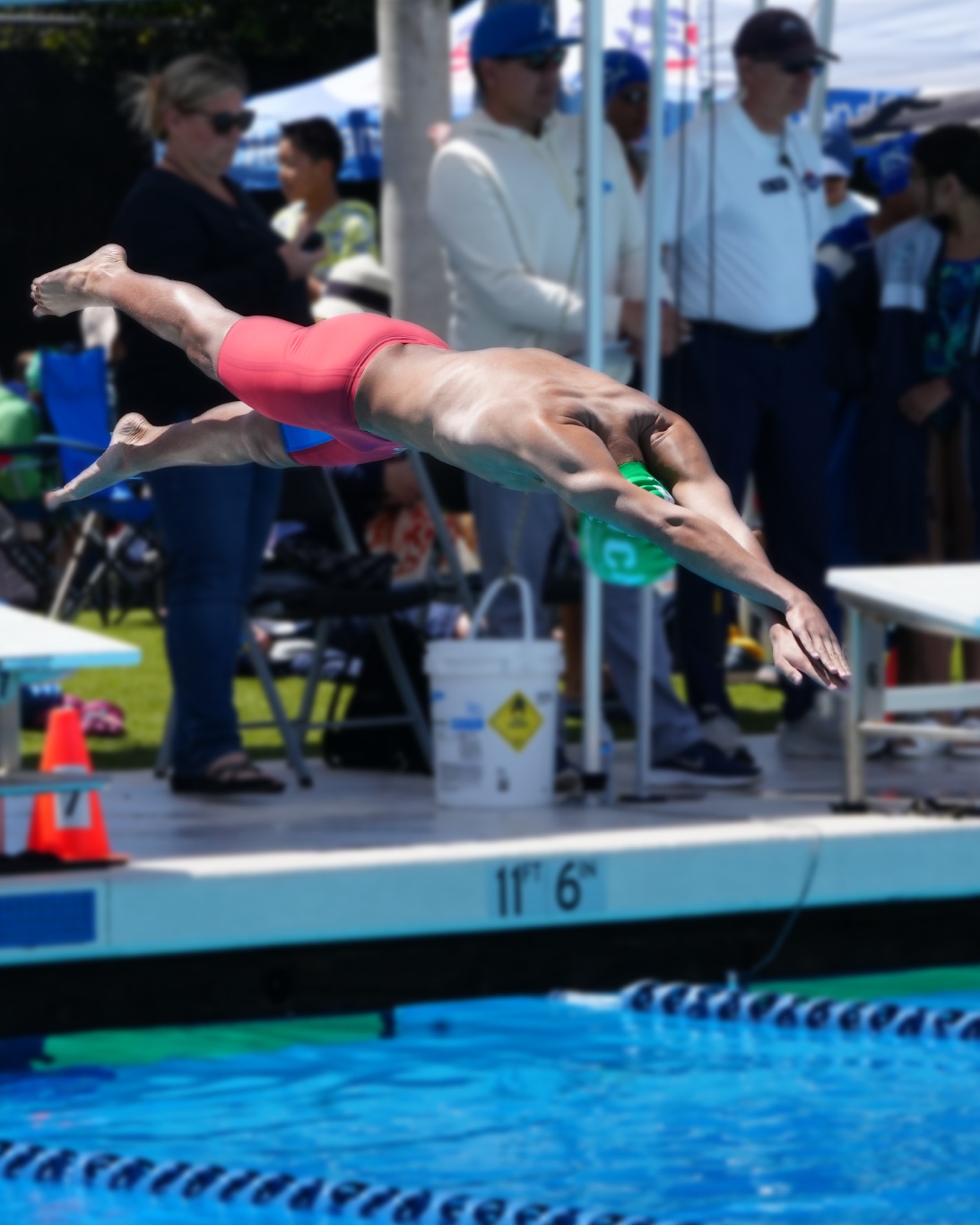 Diver mid-air off the diving board at a swim meet